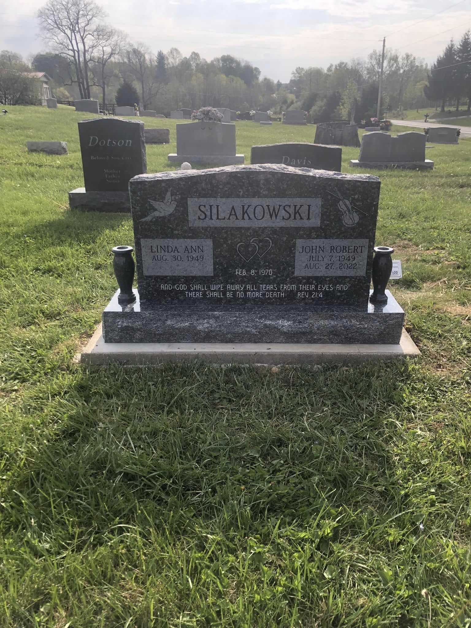 Silakowski family monument with historic church steeple visible in the lush green cemetery grounds